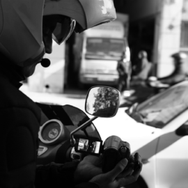 Detective privado realizando labores de vigilancia y observación en la vía pública con cámara
