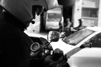 Detective privado realizando labores de vigilancia y observación en la vía pública con cámara