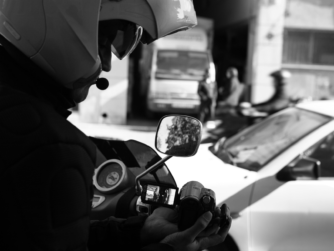 Detective privado realizando labores de vigilancia y observación en la vía pública con cámara