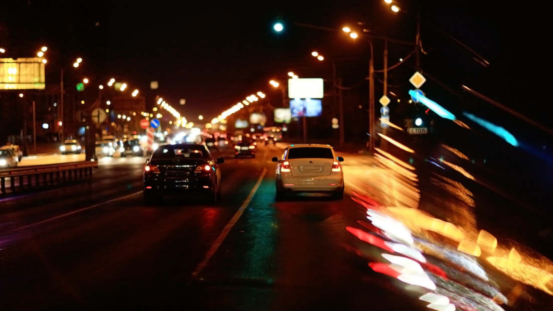 Vehículos circulando de noche en una carretera urbana durante un seguimiento discreto