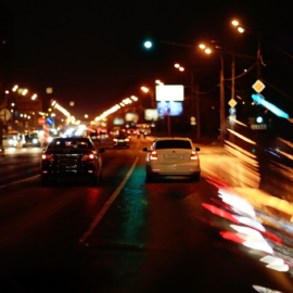 Vehículos circulando de noche en una carretera urbana durante un seguimiento discreto