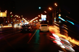 Vehículos circulando de noche en una carretera urbana durante un seguimiento discreto