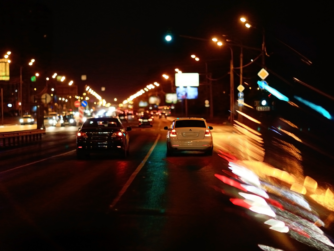 Vehículos circulando de noche en una carretera urbana durante un seguimiento discreto