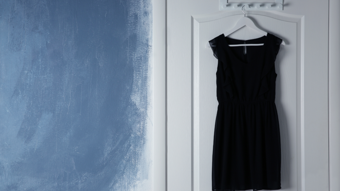 Vestido negro colgado en una puerta esperando una noche de vigilancia