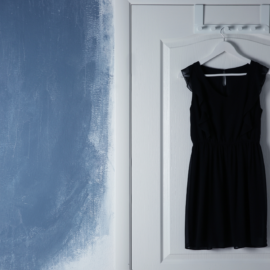 Vestido negro colgado en una puerta esperando una noche de vigilancia