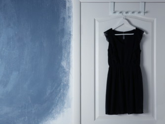 Vestido negro colgado en una puerta esperando una noche de vigilancia