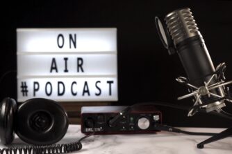 Micrófono y equipo de grabación de podcast en estudio con cartel luminoso “On Air Podcast”