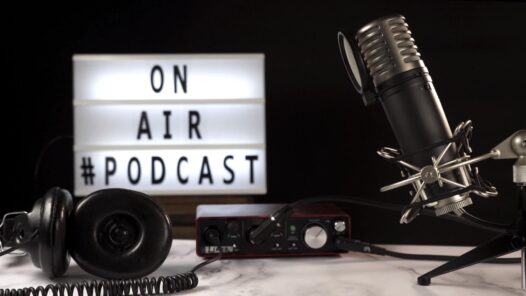 Micrófono y equipo de grabación de podcast en estudio con cartel luminoso “On Air Podcast”